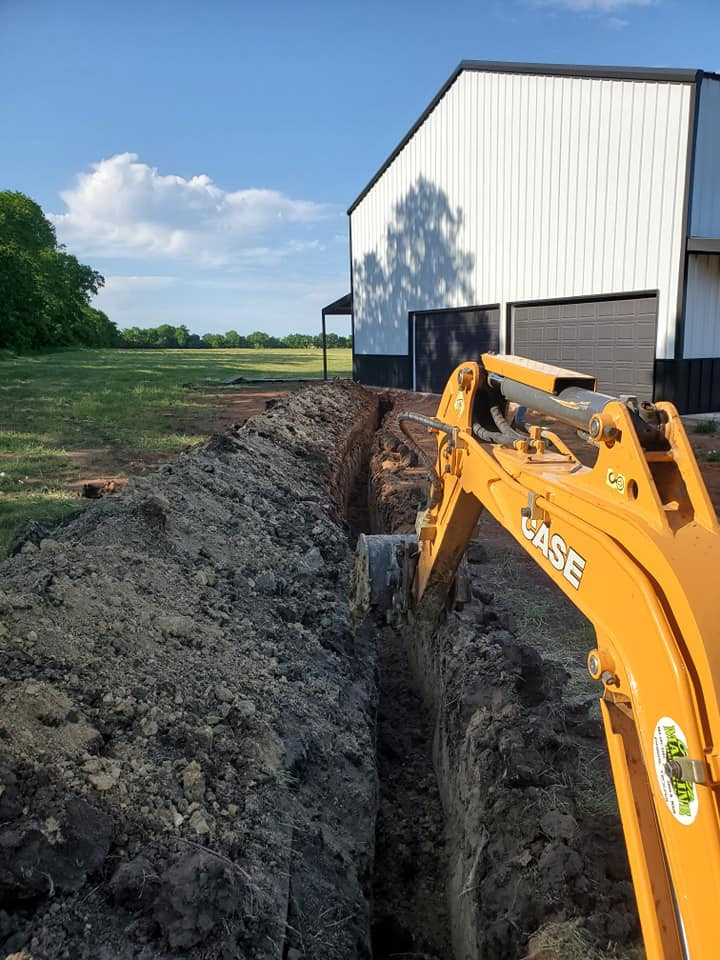 cavar con un tractor mientras se construye un barndominio